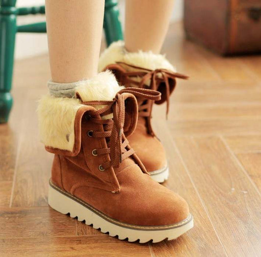 Frosted fur boots in brown with lace-up front, flat heel, and white sole designed for snow and winter wear
