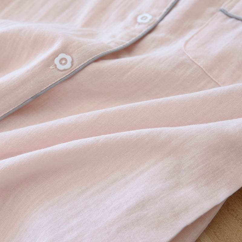 Close-up of light pink three-piece cotton gauze pajamas for women with flower-shaped buttons